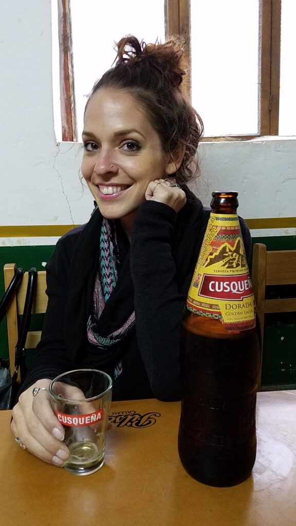 Linds with a giant Cusqueña beer, sitting in a bar in Ollantaytambo, Peru