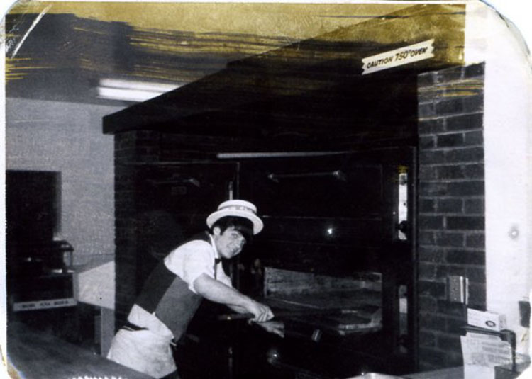 My dad, young, working at a pizza parlor baking the pizzas