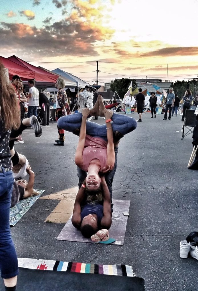 Partner Yoga underneath the Giant, Italian chair at Sunstock, Solar Powered Environmental and Social Justice Festival