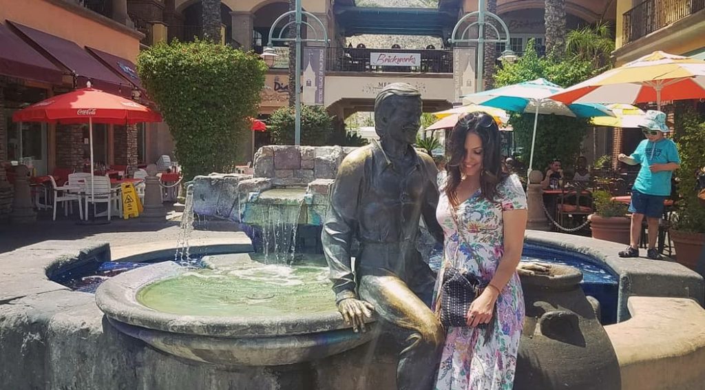 Linds posing with a Sonny Bono Statue, Palm Springs