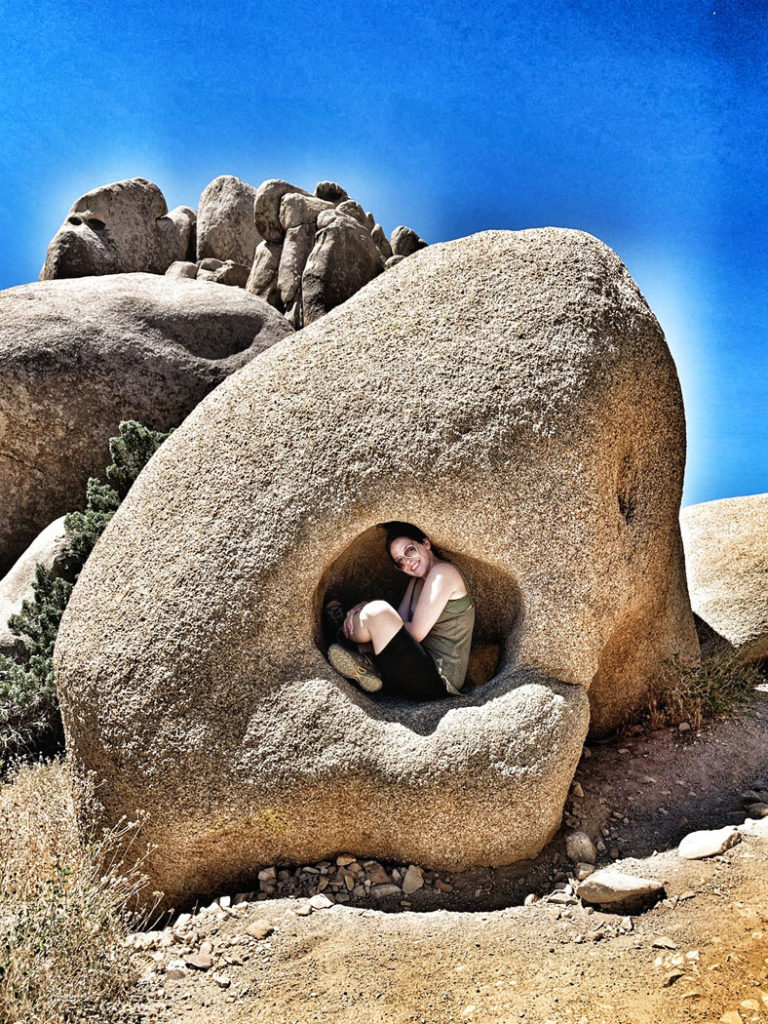 Linds crouched in a boulder in Joshua Tree National Park