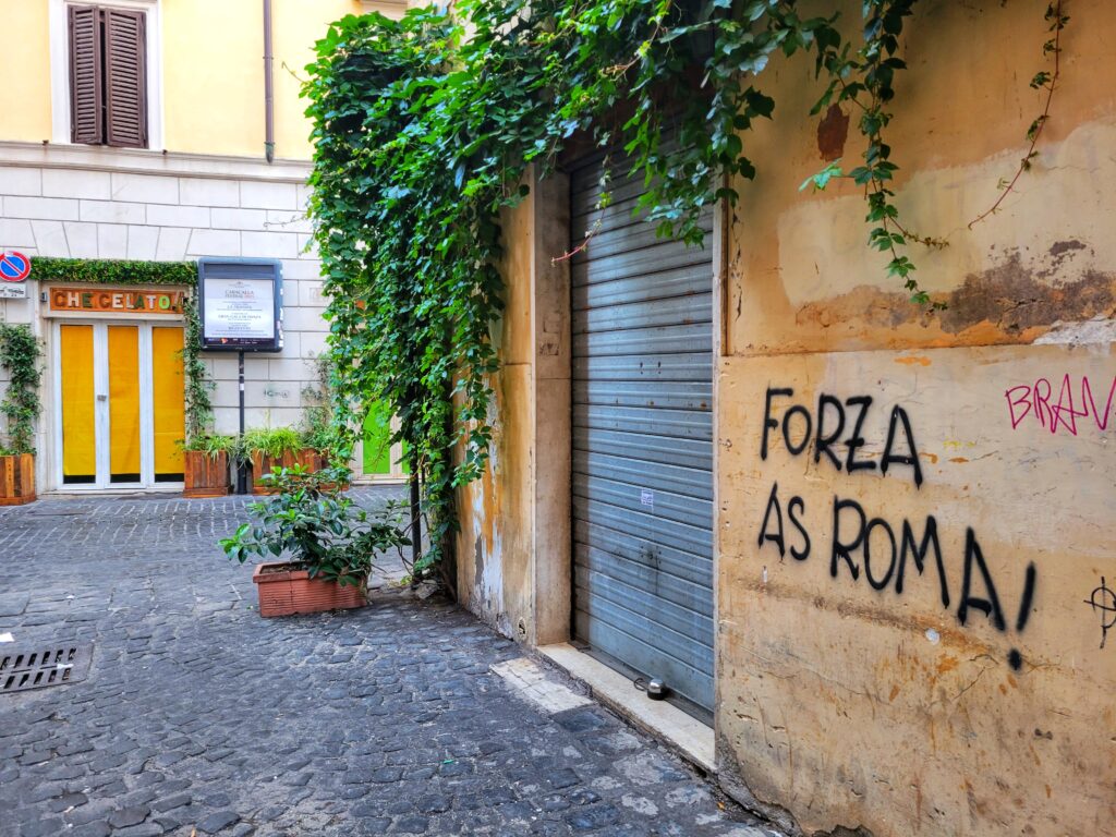 Forza As Roma graffiti on a storefront in Rome, Italy
