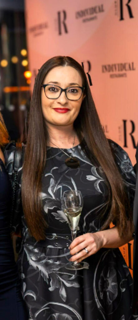 Alessia Rosini holding champagne flute and smiling toward the camera