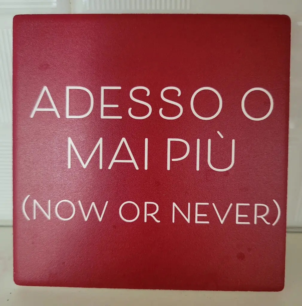 Adesso o mai più (now or never) sign in Italian - white lettering on red background