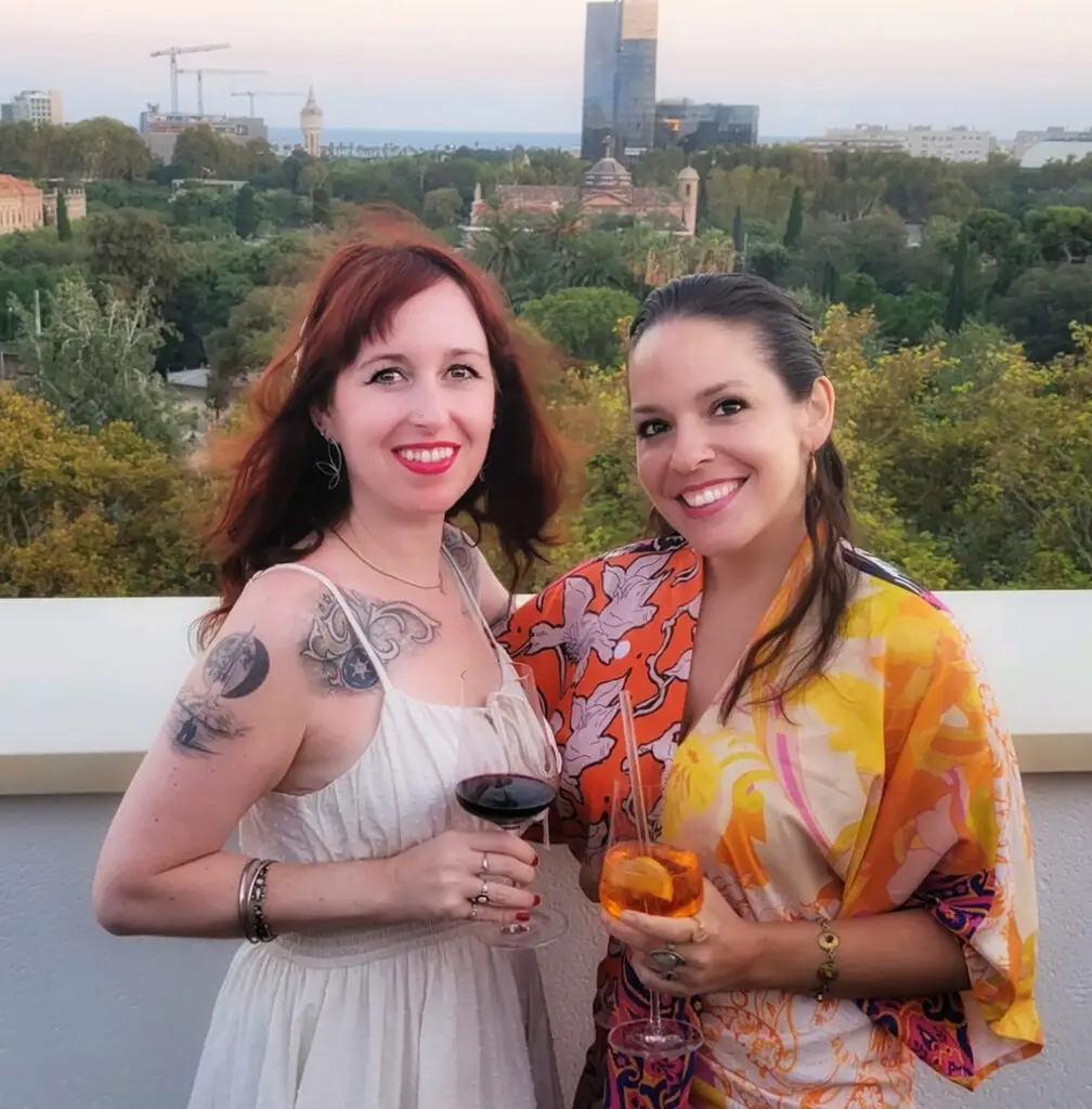 Kasey Herrin and Linds on rooftop in Barcelona with wine in hand