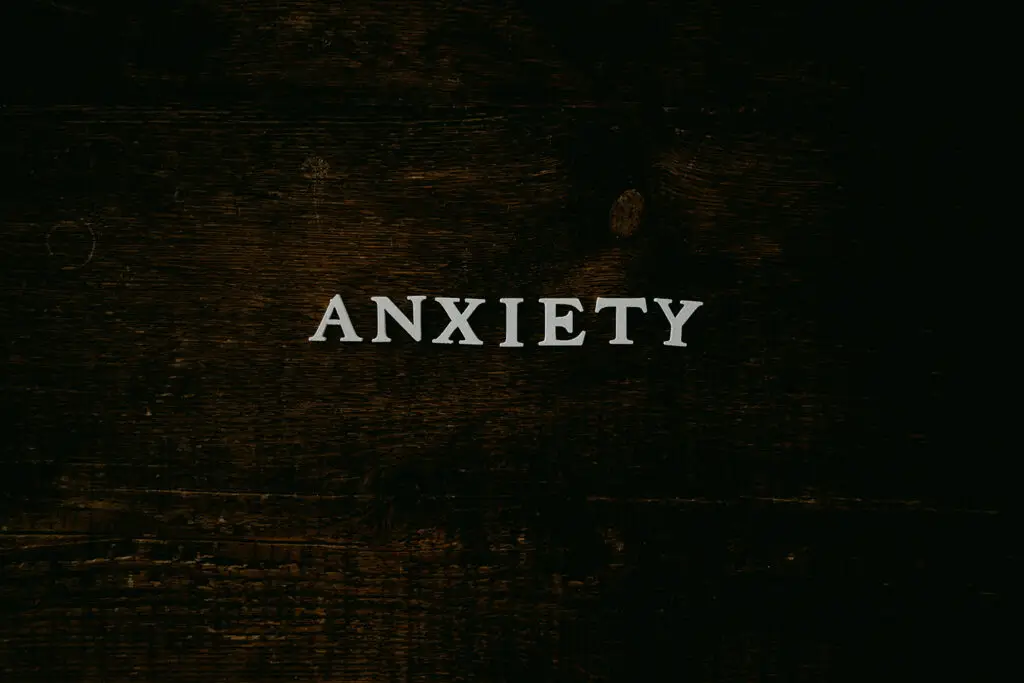 the word "anxiety" spelled out in typewriter font on dark background
