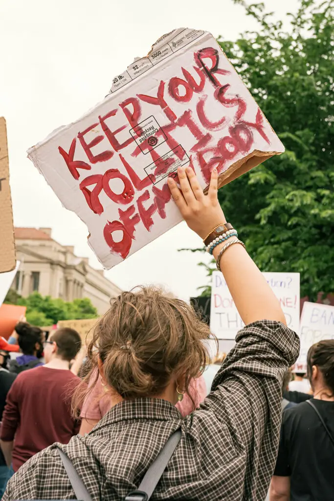 woman holding sign that reads: Keep your politics off my body