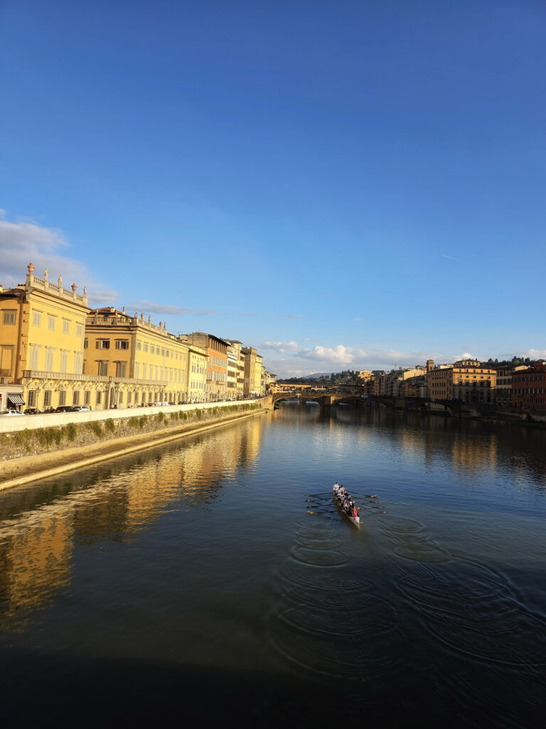 Arno River looking south at sunset, rowing team in water