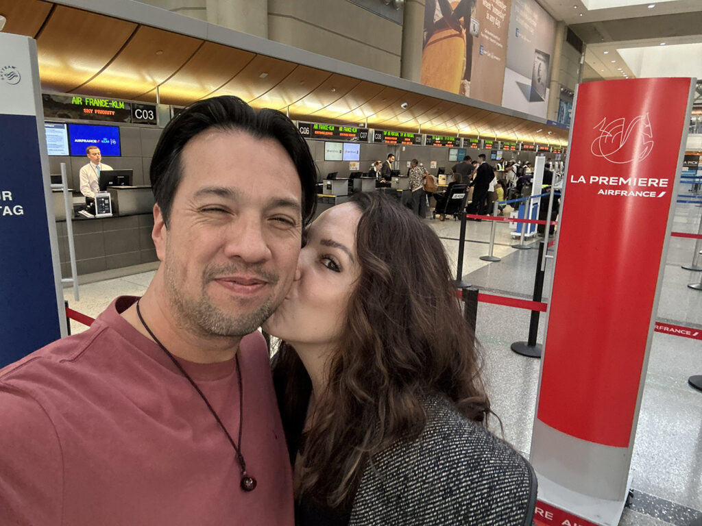 Linds kissing the cheek of her love in the airport