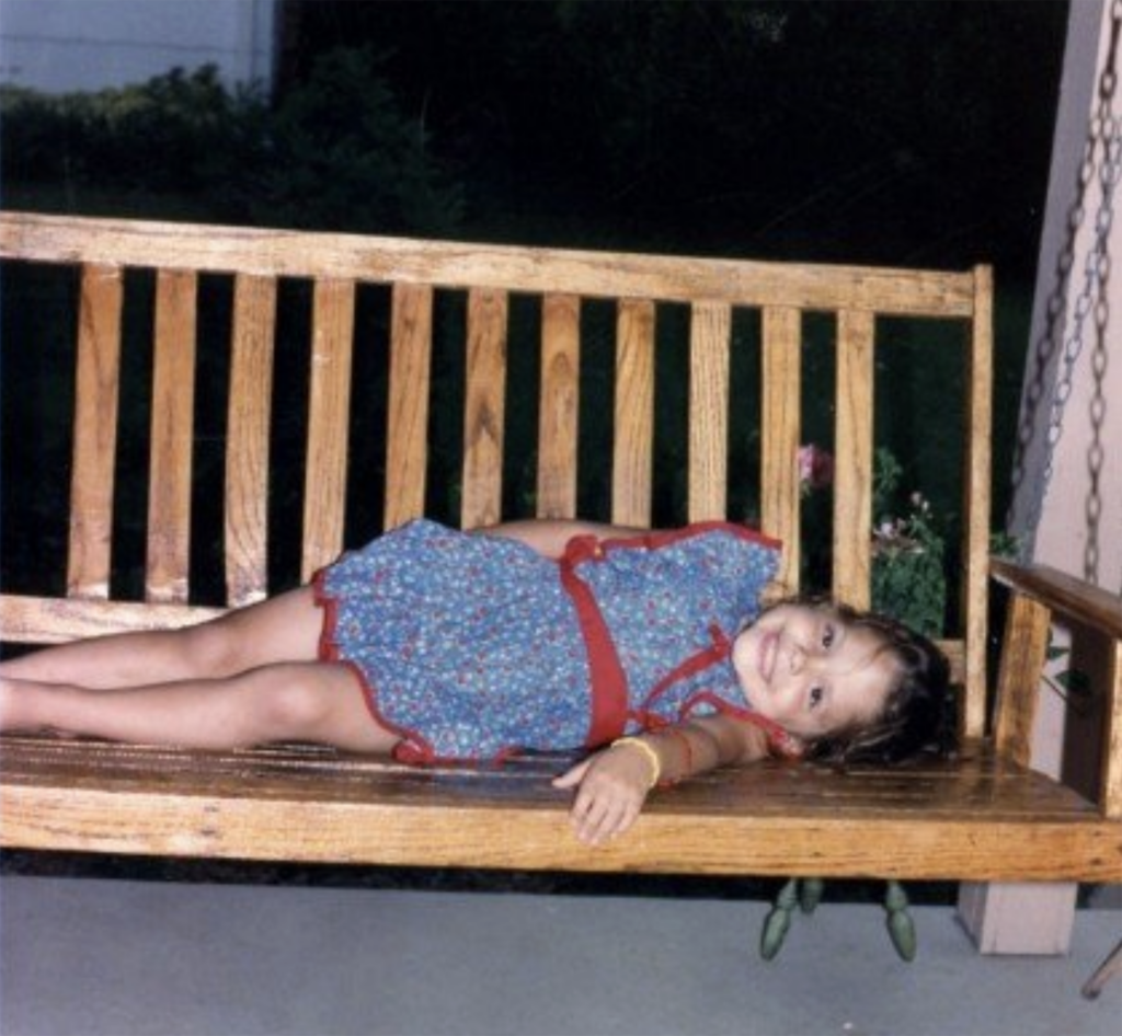 Seven-year-old Linds lying down on a porch swing