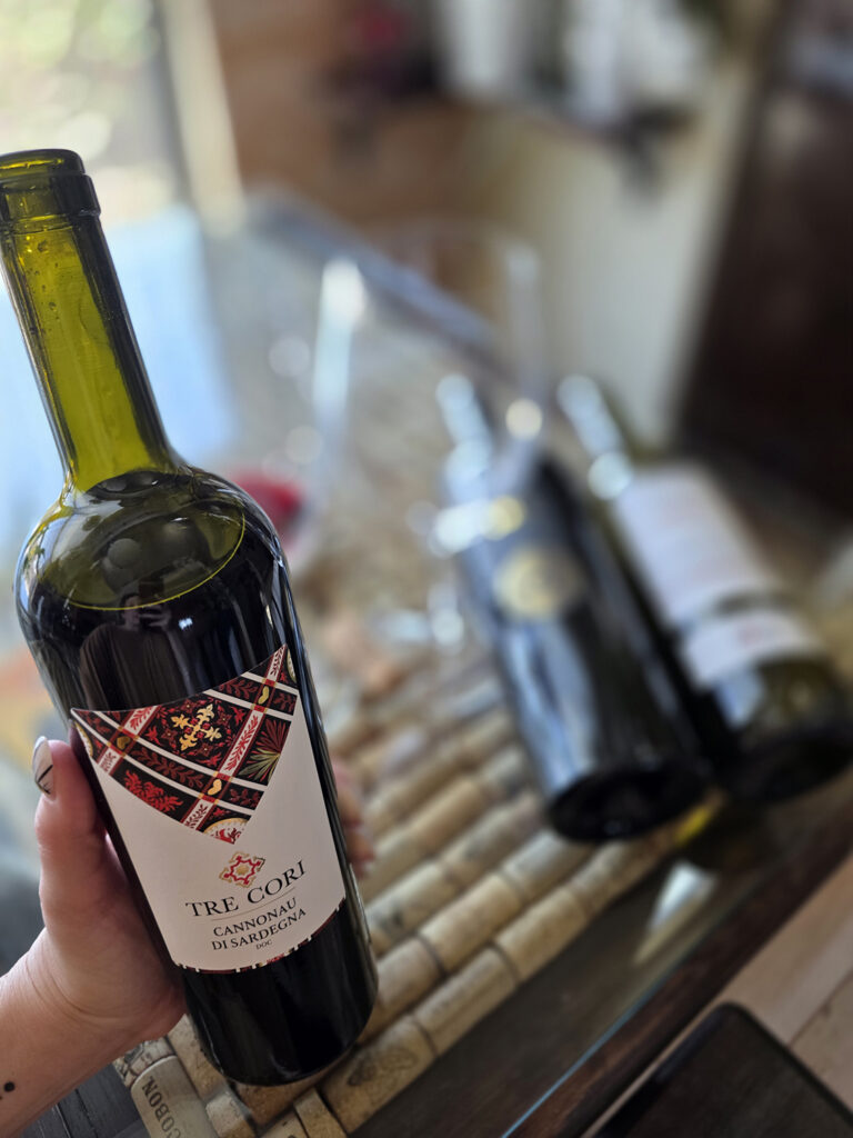 up close of Linds holding a bottle of Tre Cori Cannonau di Sardegna